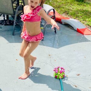 ella playing in sprinkler