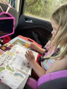 Ella uses Colorforms in the car