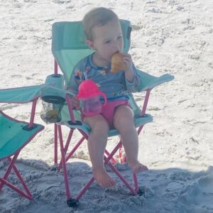 Ruthie eats a snack in her beach chair