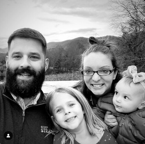 picture of a family of four ("The Kind of Crafty Mom" and her husband and two daughters) in front of a mountain