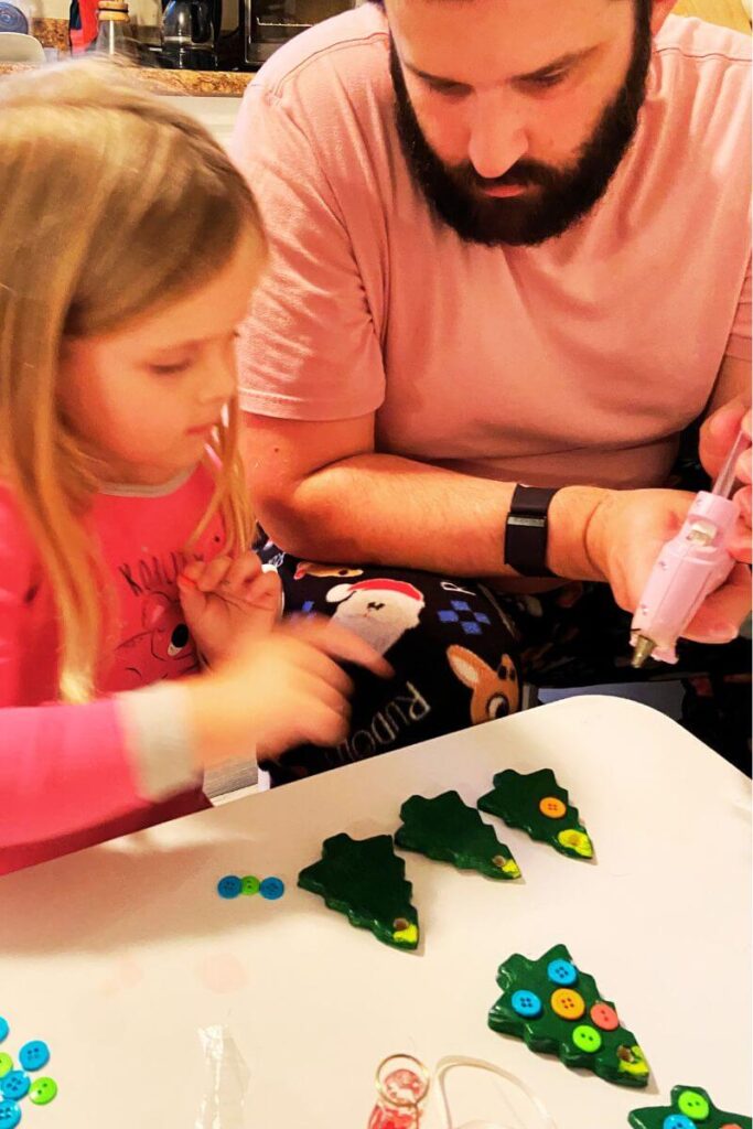 ella and colin add buttons to salt dough ornaments with hot glue