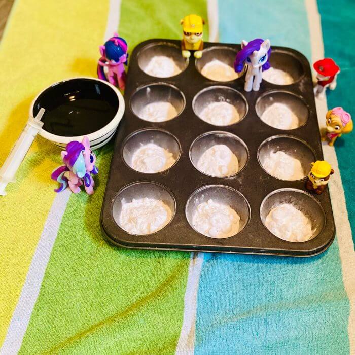 muffin tin with baking soda and vinegar set up for sensory play