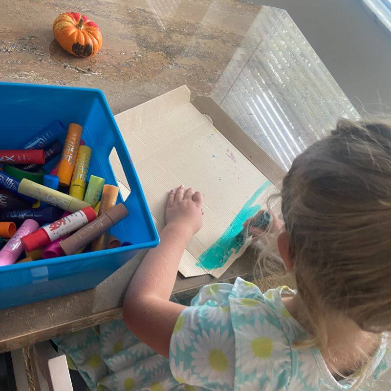 Ella painting with paint sticks.