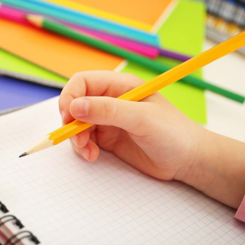 child writing in notebook