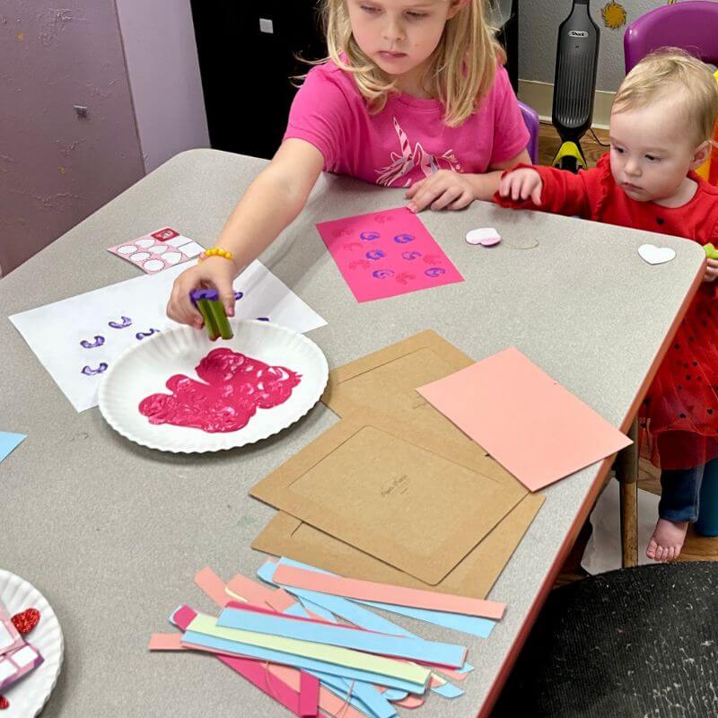 child using celery and paint to create heart stamps