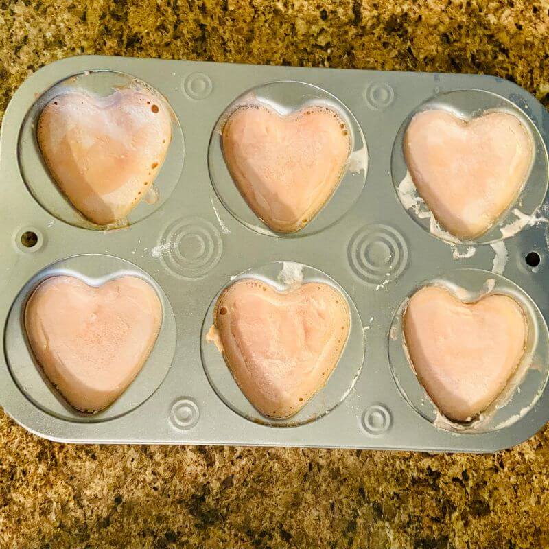 heart shaped muffin tin with pink baking soda mixture