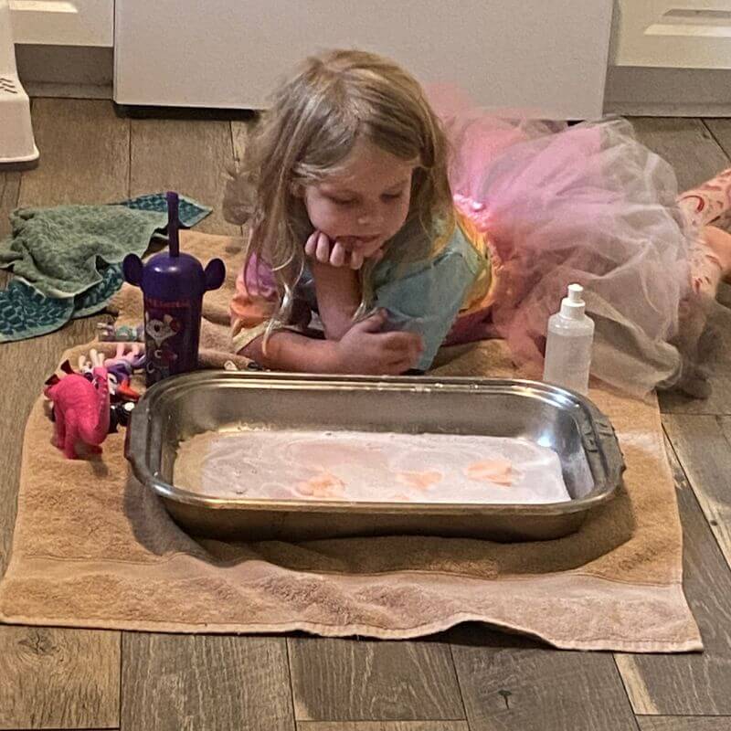 young girl observing fizzy heart STEM activity