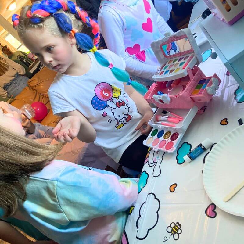 Ella putting makeup on her friend