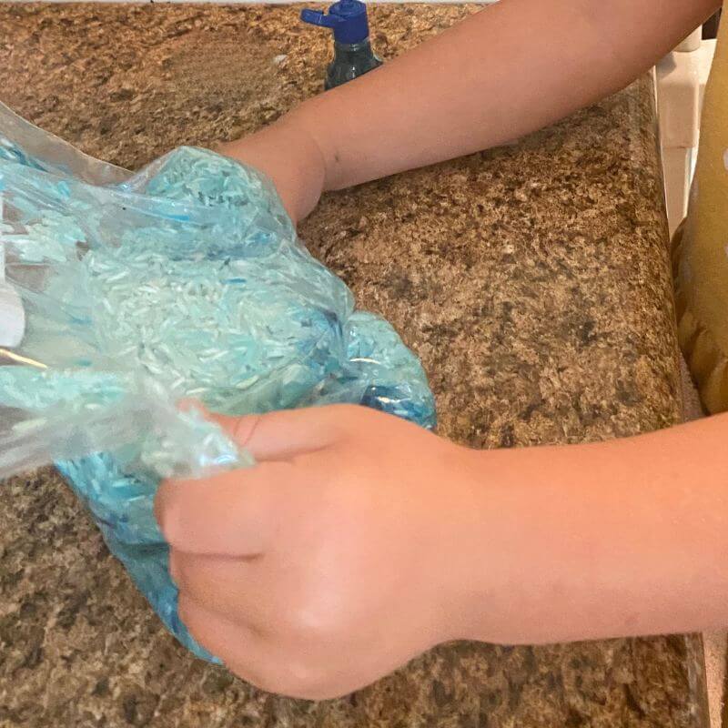 rice being dyed blue in a bag