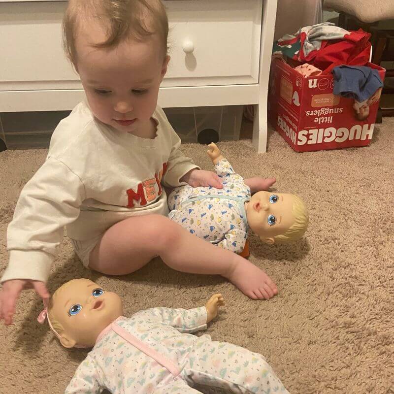 toddler playing with baby dolls