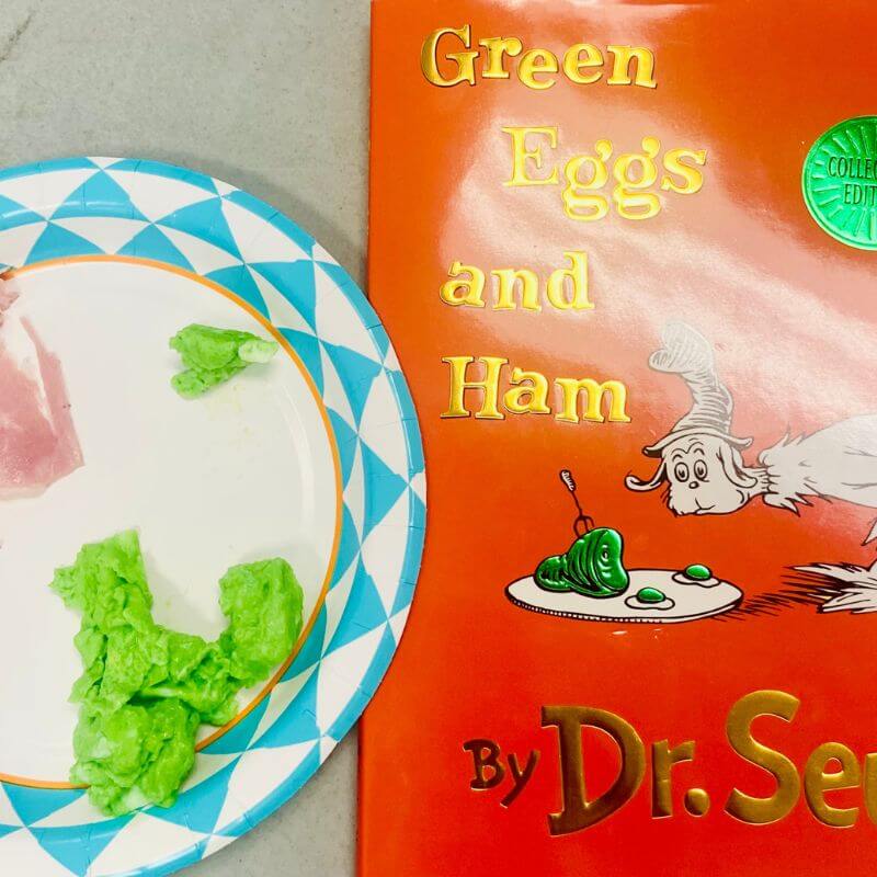 green eggs and ham on a plate next to book