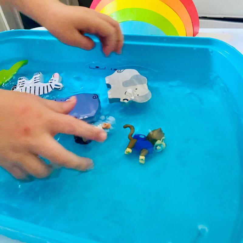 child playing with toys in sensory bin