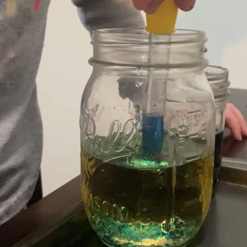 oil and water forming colorful bubbles as part of a science experiment