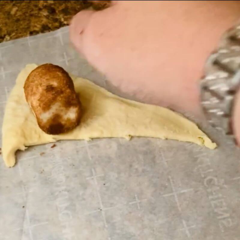 placing marshmallow on crescent roll dough